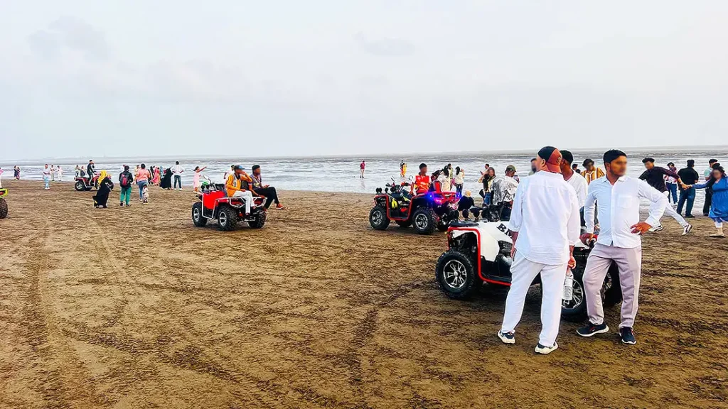 ATV quad bike rides on the sand at Dumas Beach Surat with tourists near the shoreline