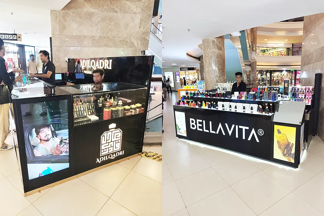 Adil Qadri and Bellavita fragrance kiosks inside Surat VR Mall, both displaying perfume bottles on black counters