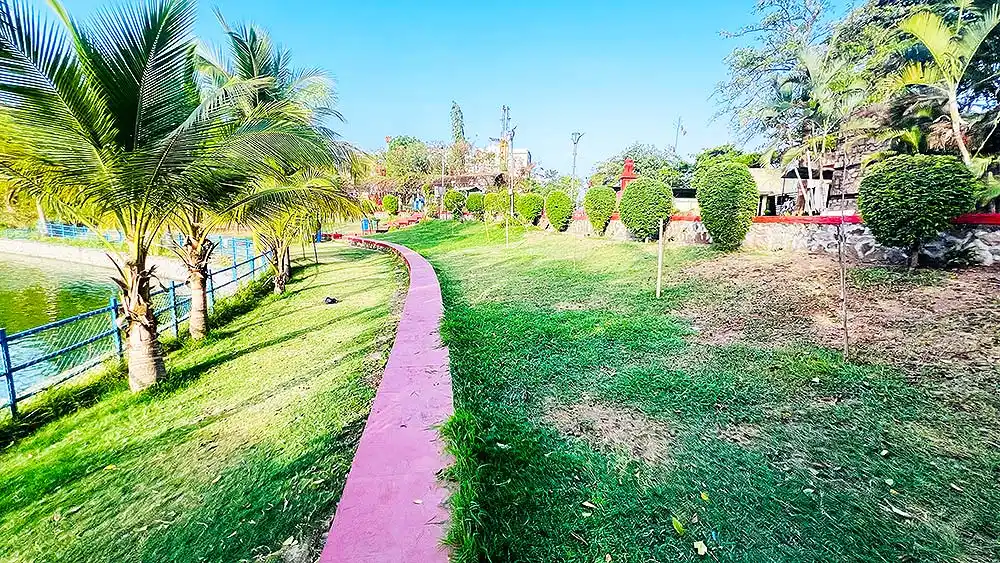 Lush greenery all around at Botanical Garden Surat with pink path, palm trees and lake view