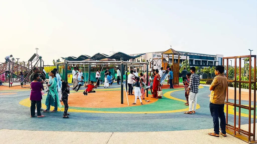Kids on swings at the play area in Dumas Sea Face Surat