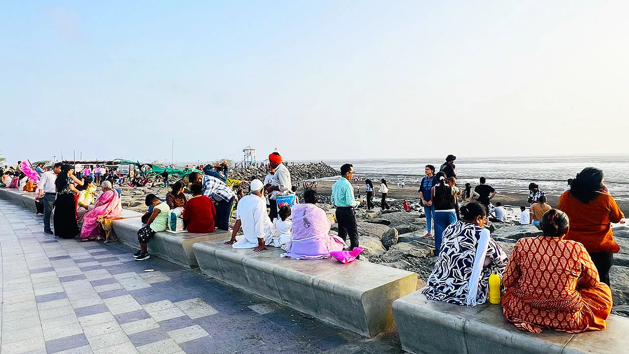 Dumas Sea Face Surat seating wall with families enjoying evening view