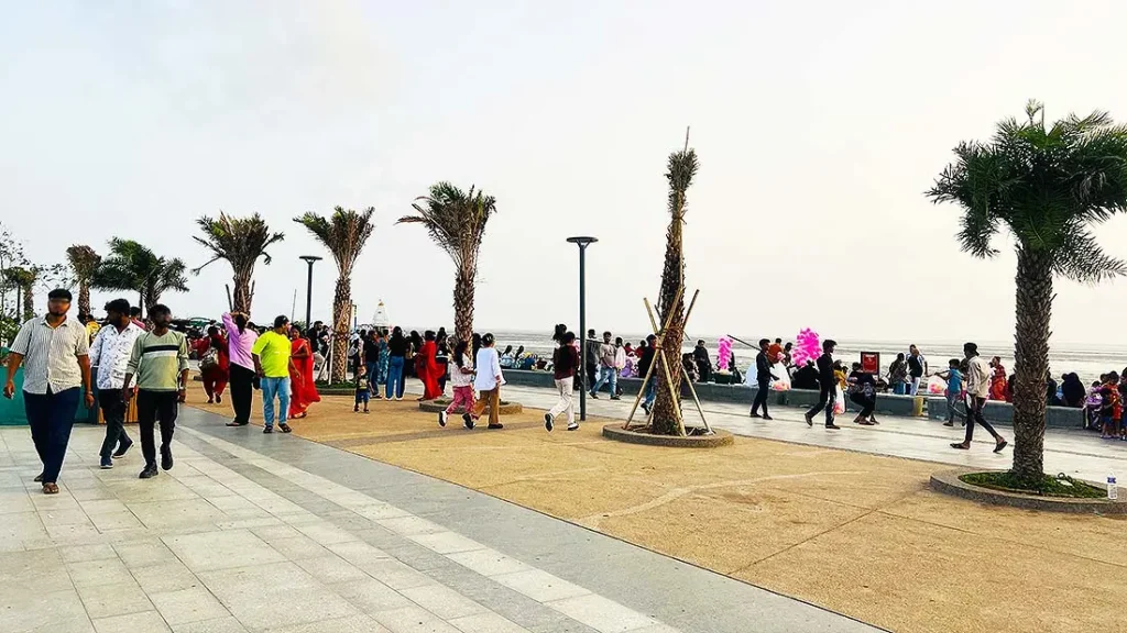 Visitors walking along the palm lined walkway at Dumas Sea Face Surat