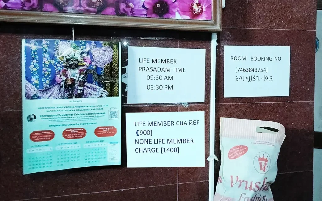 Notice board at ISKCON Temple guest house showing room booking number and Life Member charges