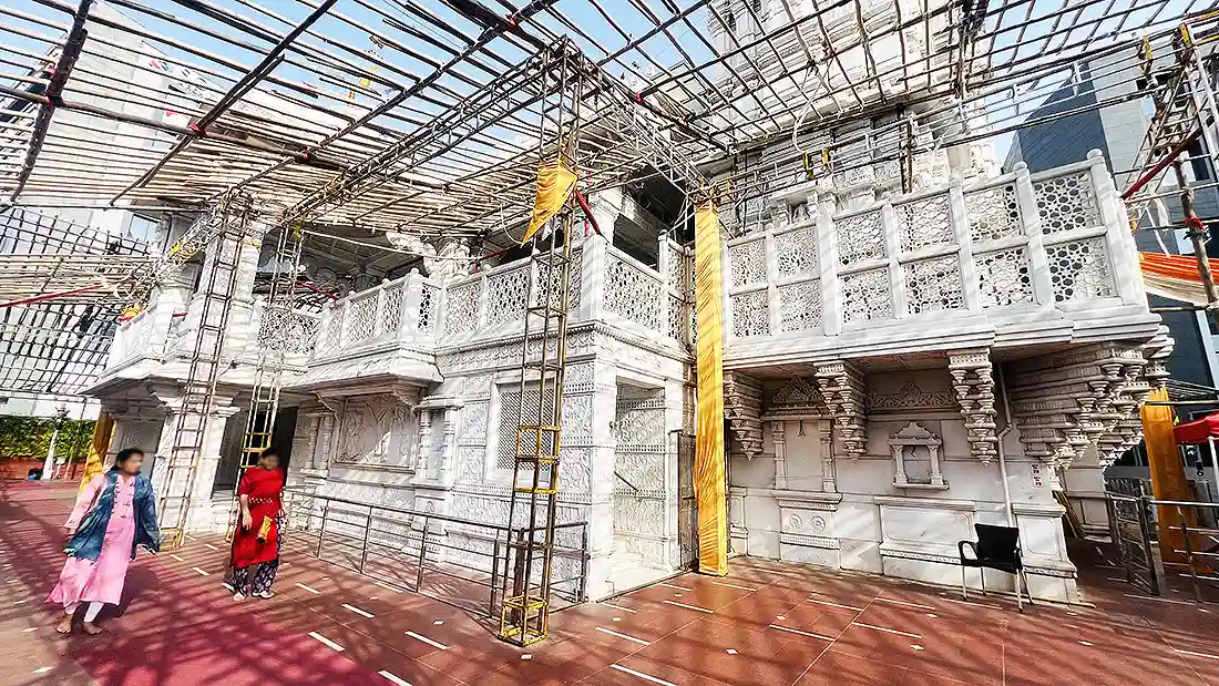 Back side view of the carved white marble Shyam temple on New City Light Road, with a canopy frame overhead