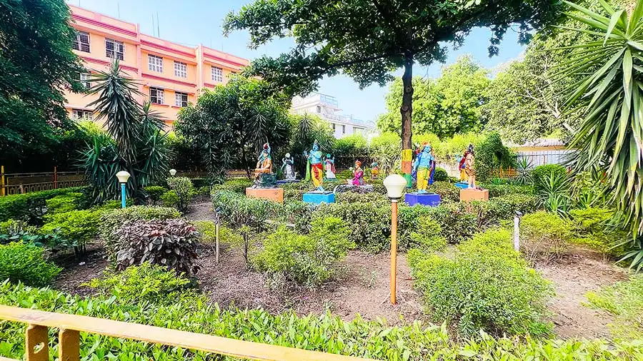 Colourful statues among trees in the Natural Park garden at Gurukul Surat