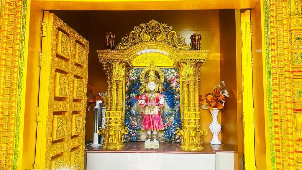 Deity idol inside golden Radha Krishna small mandir at Gurukul Surat