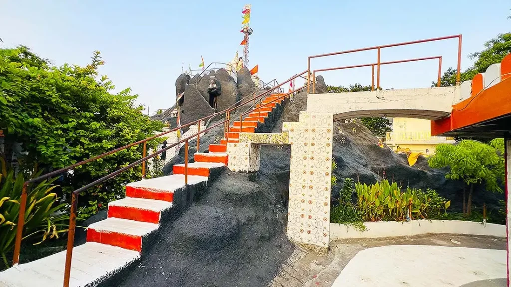 Narrow stairs climbing up Mini Girnar Ram Madhi Surat with orange steps on rocky structure