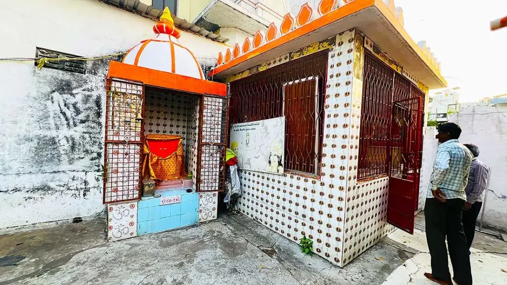 Small temple behind Mini Girnar Ram Madhi Surat with deity and devotees standing nearby