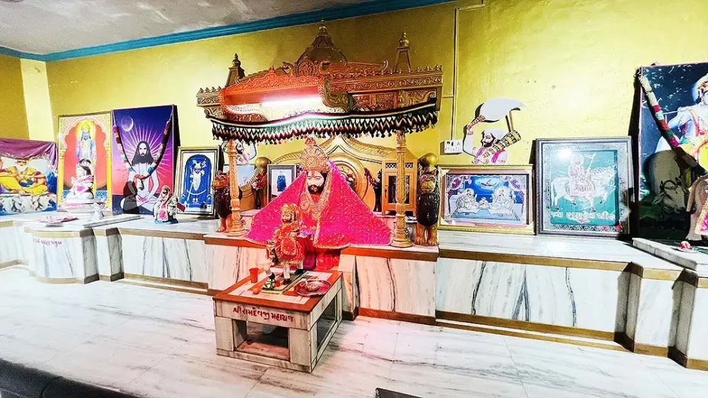 Ramdev Pir Bhagwan deity for darshan inside mandir at Ram Madhi Surat with framed photos