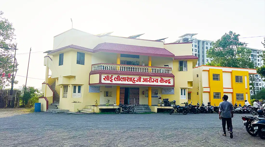 Sai Lilashahji Aarogya Kendra, a cream and maroon health centre building inside the Jahangirpura ashram, bikes parked outside