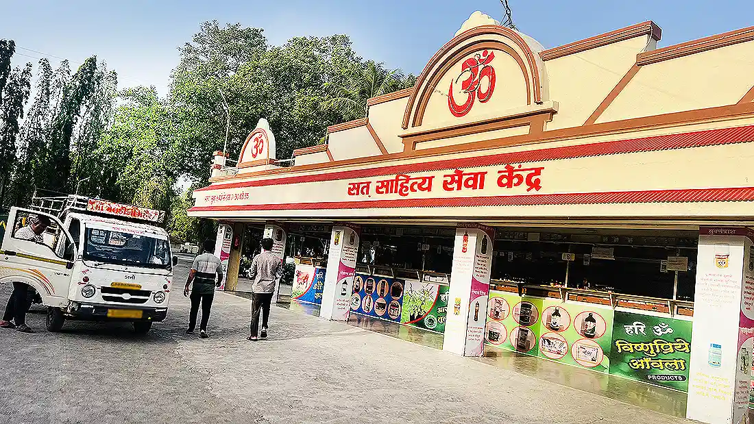 Satt Sahitya Seva Kendra shop at the ashram, an Om topped building selling ayurvedic products, with a tempo parked outside