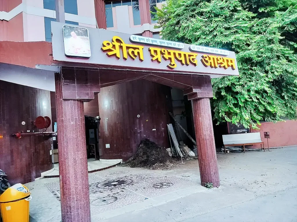 Shril Prabhupada Ashram guest house at ISKCON Temple with name board and covered porch on red pillars