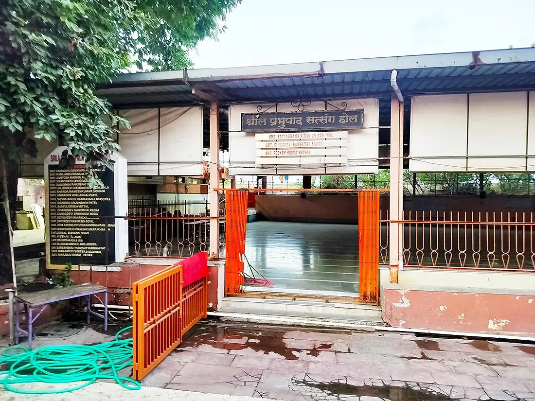 Shril Prabhupada Satsang Hall at ISKCON Temple with name board, orange gate and open hall floor