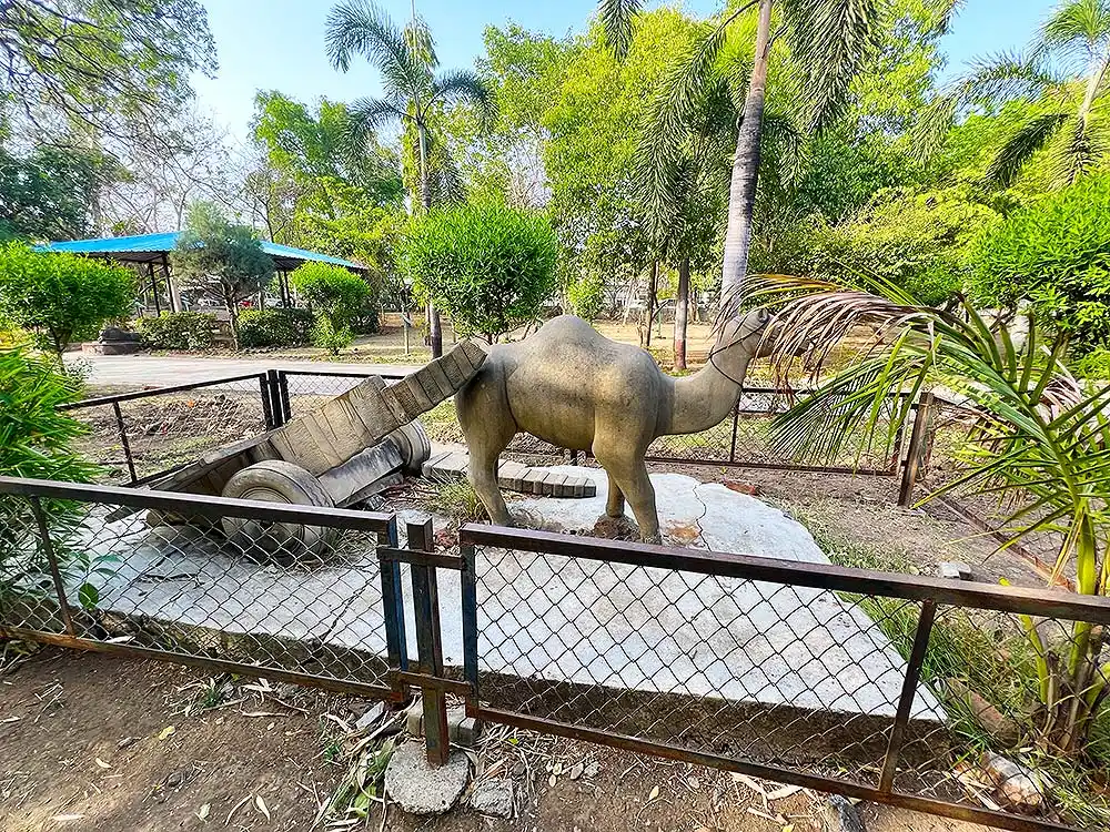 Camel statue inside Sneh Rashmi Botanical Garden Surat with green trees in background