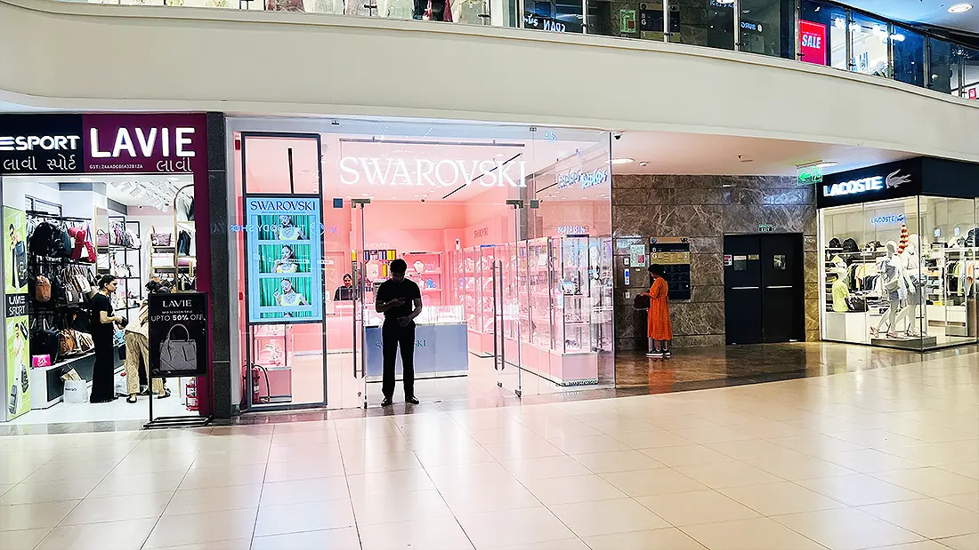 Swarovski jewellery store between Lavie and Lacoste outlets inside Surat VR Mall, with shoppers browsing