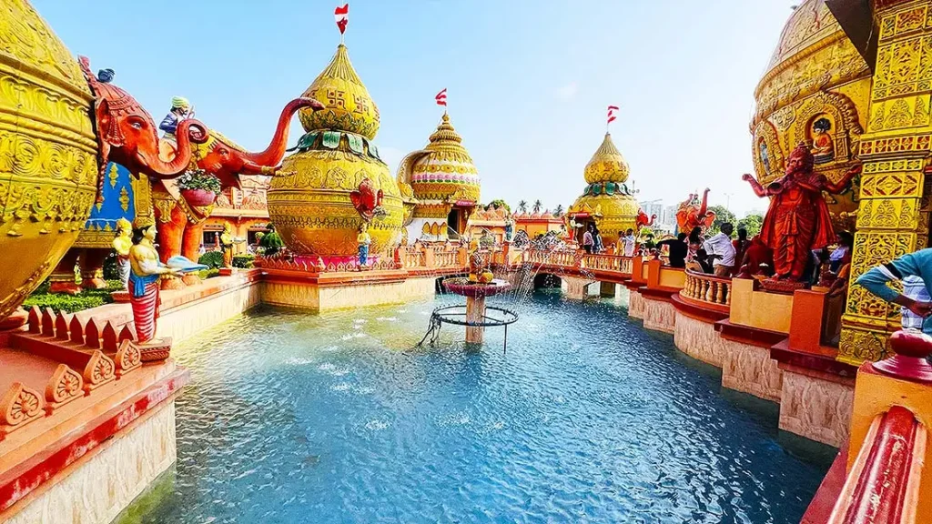 Water talab with fountain and golden kalash domes at Gurukul Surat