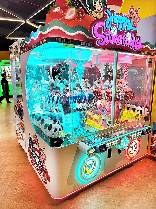 Colorful Happy Sweet Day claw machine at VR Mall game zone, filled with panda and koala soft toys under neon lights
