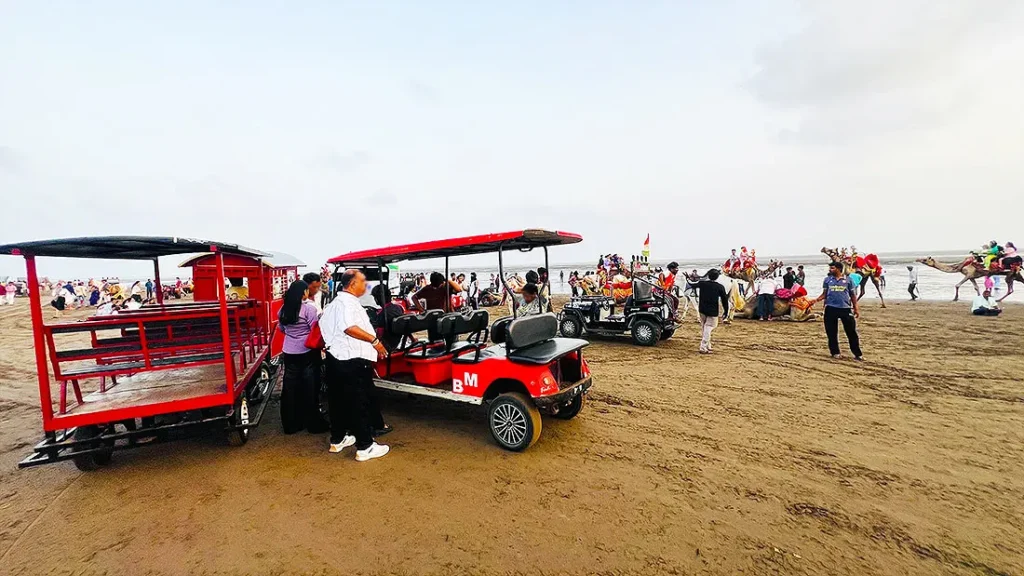 Toy car and camel ride at Dumas Beach Surat with tourists enjoying the evening