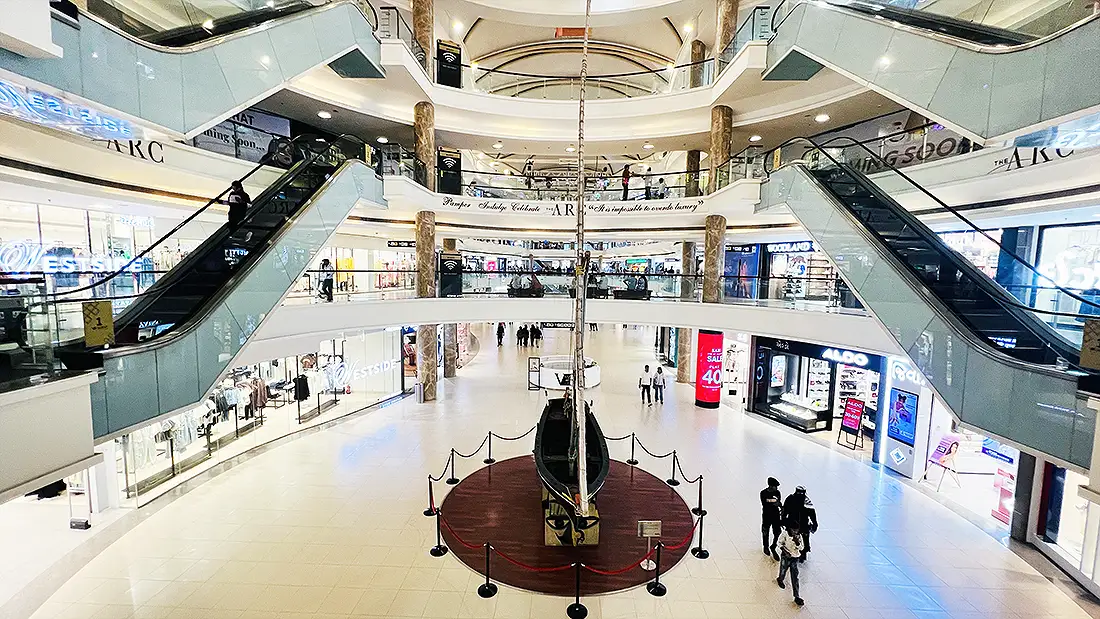 Multi level inside look of Surat VR Mall with escalators, marble pillars and a boat display on the ground floor